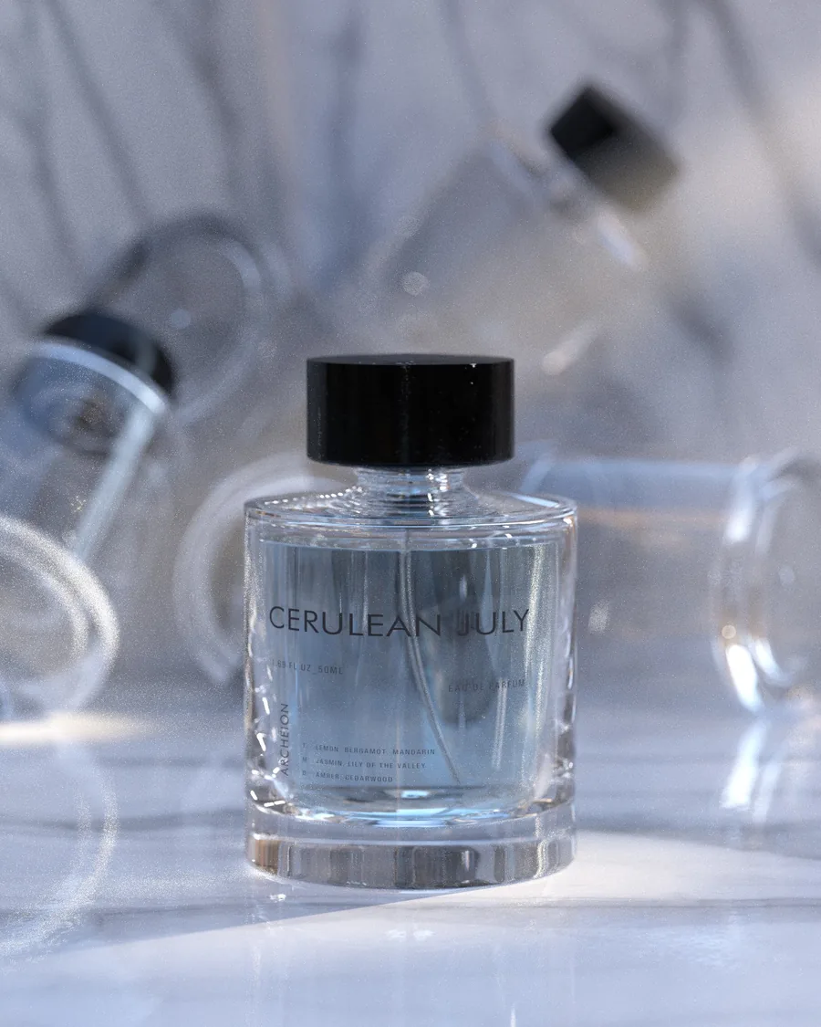 A clear perfume bottle labeled Cerulean July on a pale blue set